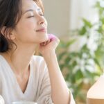 ディフューザーの香りの中で、目を閉じてくつろぐ女性